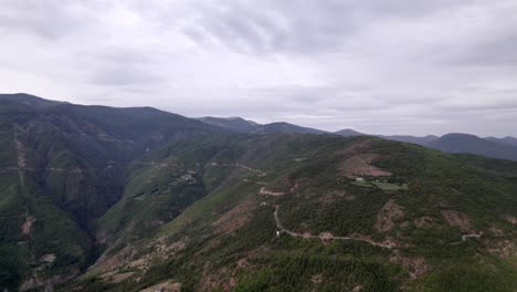 "golden-hour"-head-on-drone-video-moving-over-the-mountains-of-SH22-in-albania,-above-the-road-on-top-of-the-hill