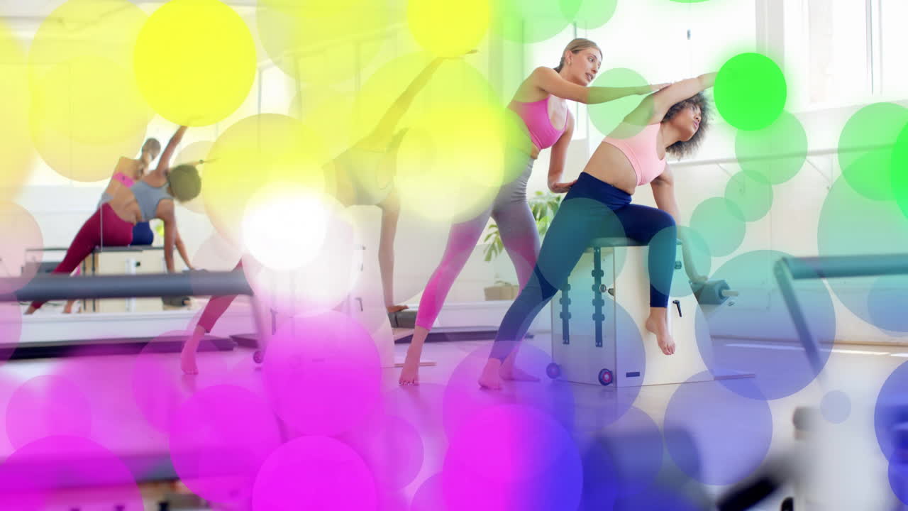 Barevná bokeh animace přes ženy cvičící jógu ve světlém studiu