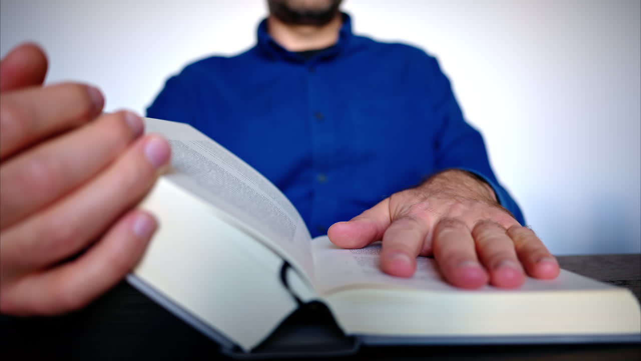 Close-up of a man reading a big book
