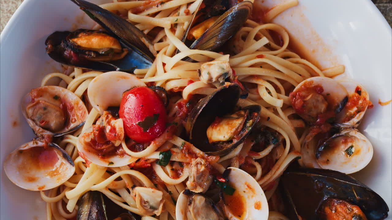 Close up of pasta with seafood and tomato sauce on a plate at a restaurant