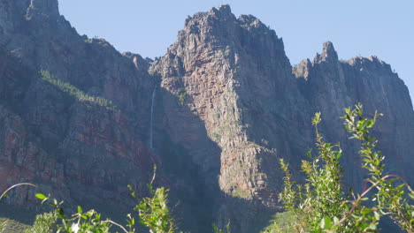 Cascada-A-La-Sombra-De-La-Montaña,-Toma-Ampliada-De-Montañas-De-Arenisca