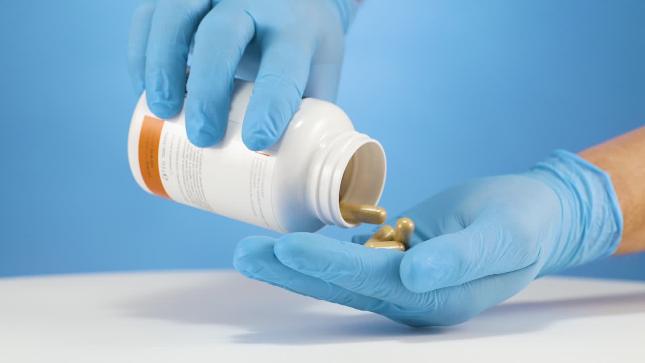 cámara lenta vertiendo tabletas médicas marrones fuera de un recipiente de plástico blanco