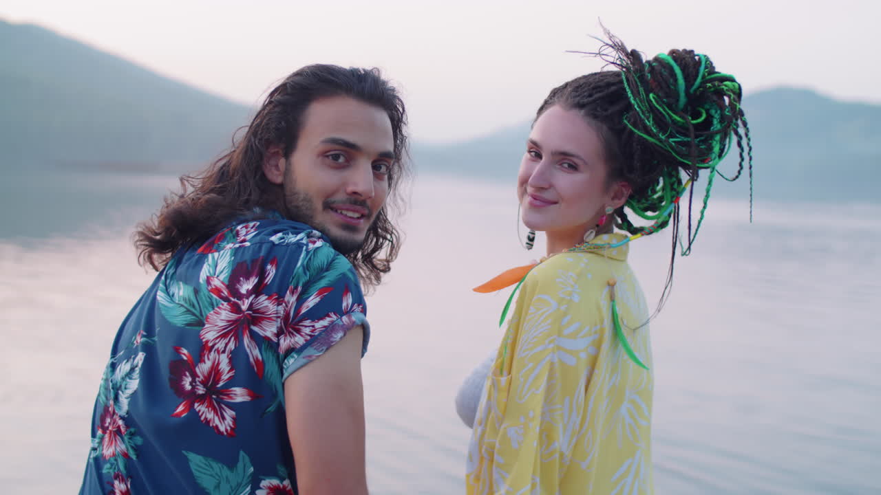 портрет счастливой многоэтнической пары, сидящей на пирсе озера