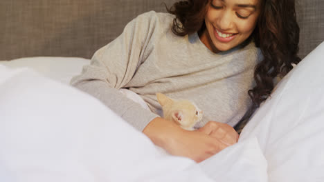 mujer joven sentada en la cama con su gato en el dormitorio 4k 4k