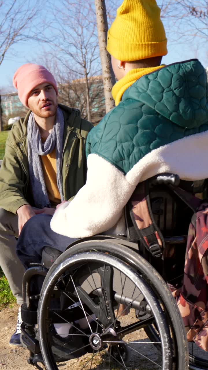 Two Young Men in a Park, One in a Wheelchair