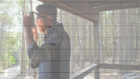 animación de gráficos y números sobre un fotógrafo caucásico haciendo clic en fotos a través de la ventana