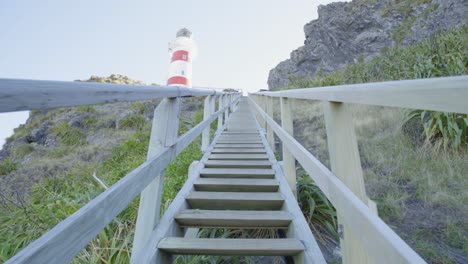 perspective shot walking up the steep wooden stairs towards a lighthouse