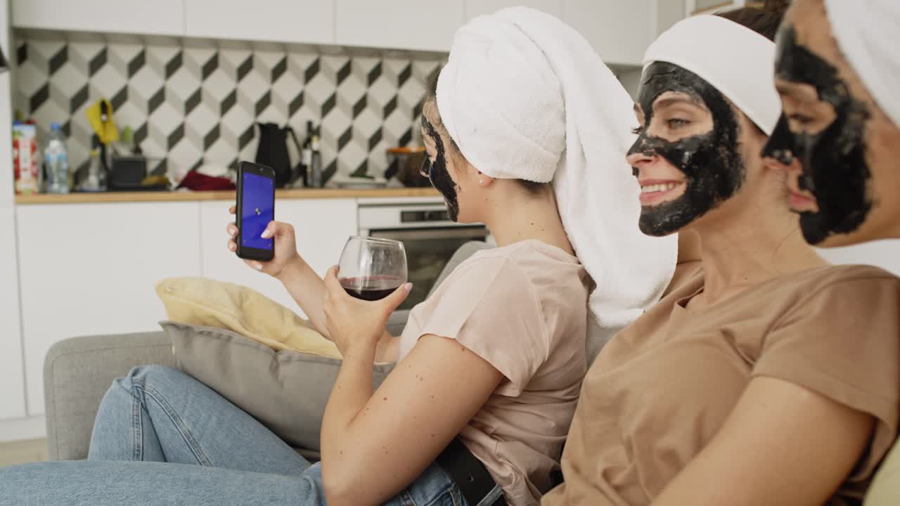Video di donne con una maschera facciale che navigano qualcosa al telefono