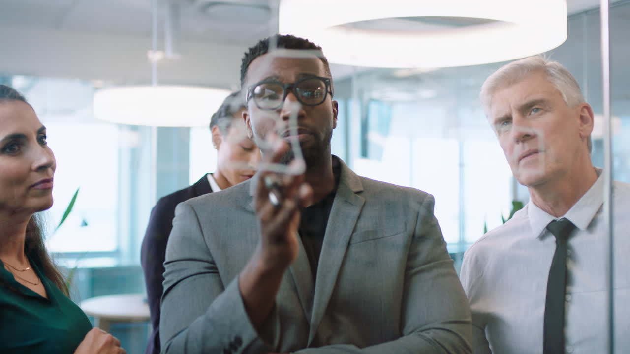 diverse business people using sticky notes african american team leader man brainstorming with colleagues working on solution discussing strategy writing on glass whiteboard in office meeting 4k