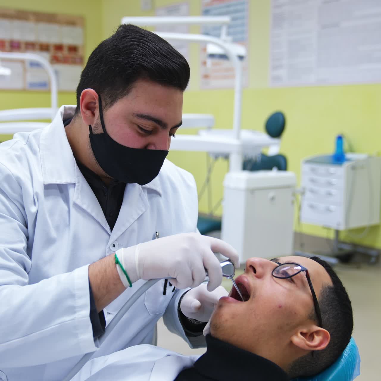 Uno studente lavora con uno strumento odontoiatrico nella bocca di un altro studente. Lezioni pratiche per studenti di odontoiatria. Sfondo sfocato.