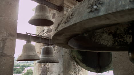 campanas de iglesia montadas en una torre alta en la plaza pública de un pequeño pueblo mexicano, que pueden ser escuchadas por la comunidad circundante