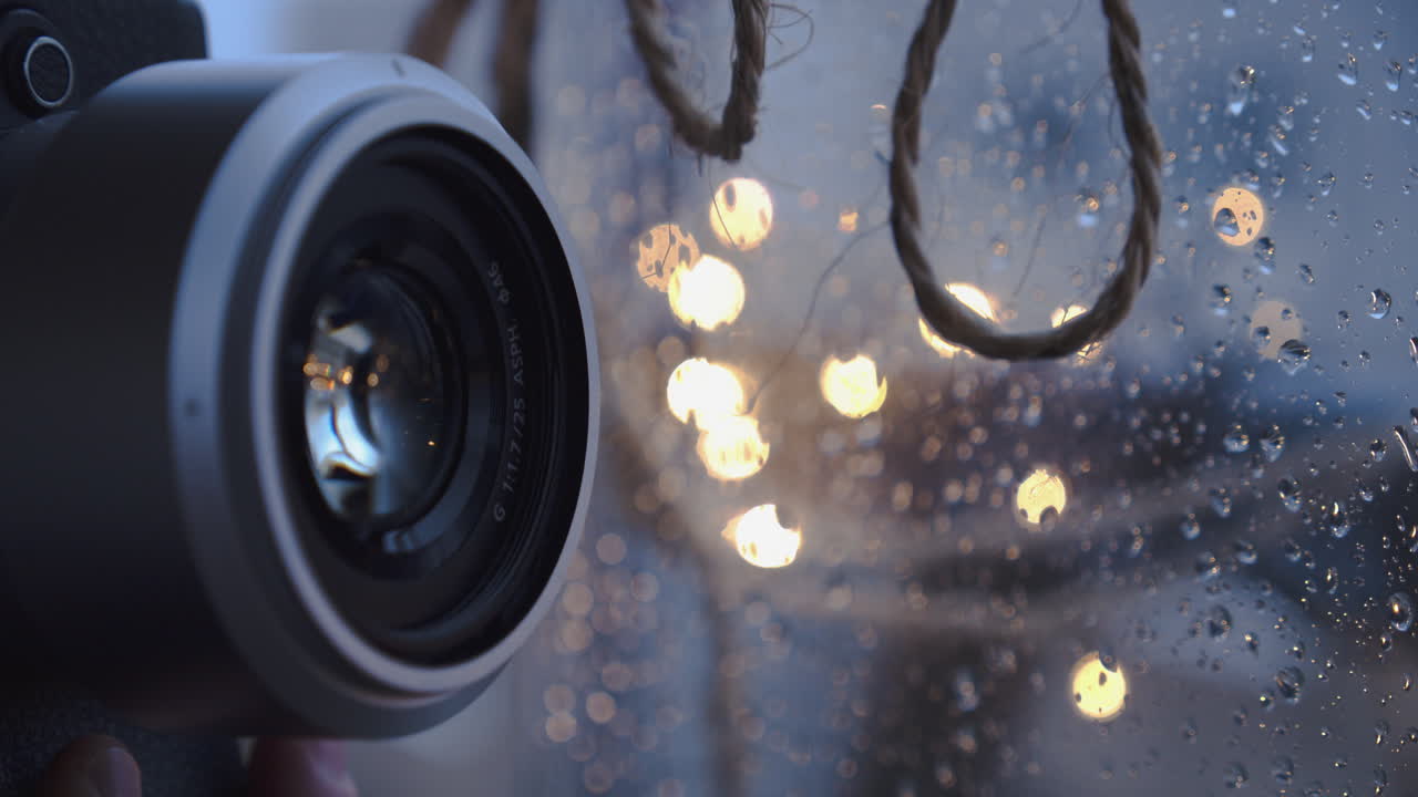primo piano dell'obiettivo di una fotocamera che scatta una foto dietro la finestra