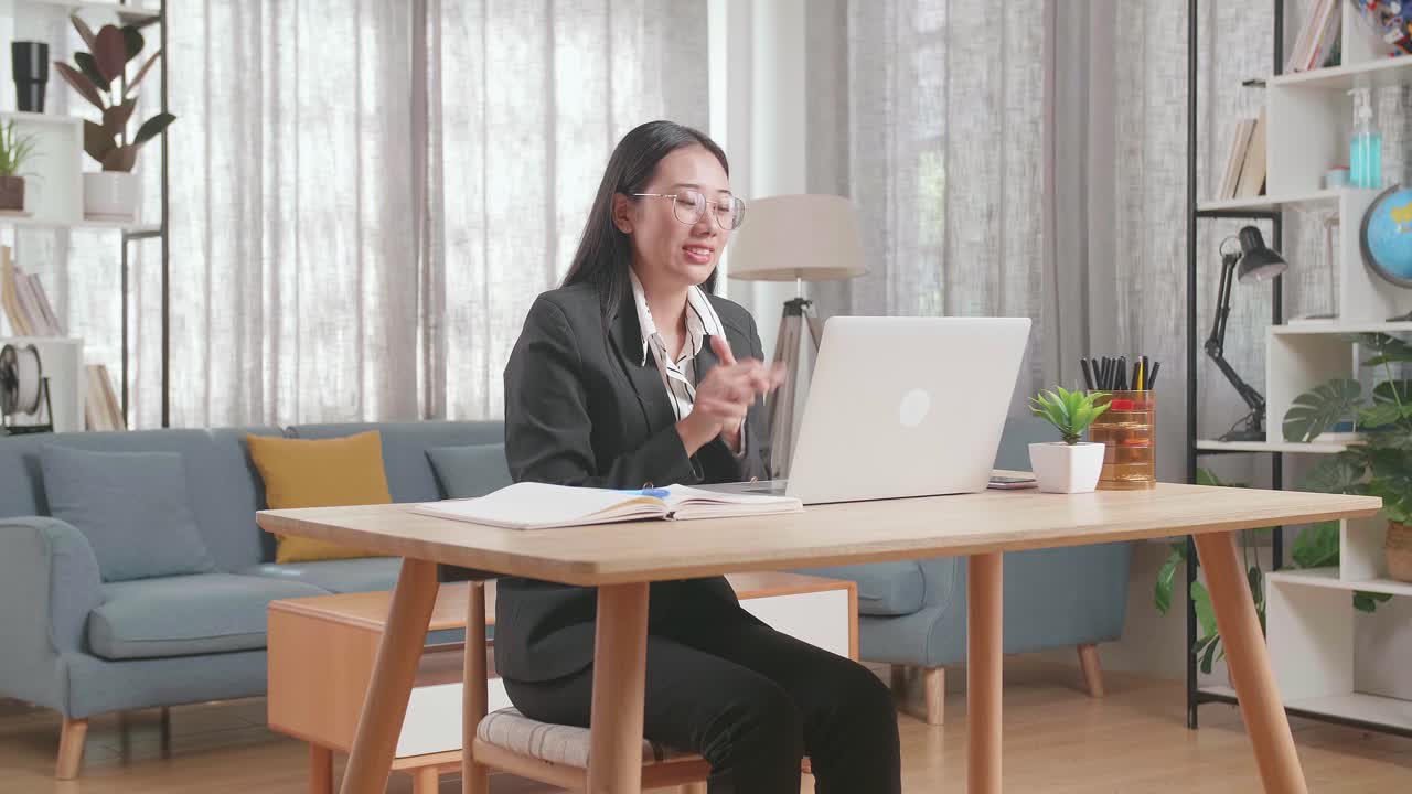 사업복 을 입은 여자 가 집 에서 비디오 회의 를 하고 있다