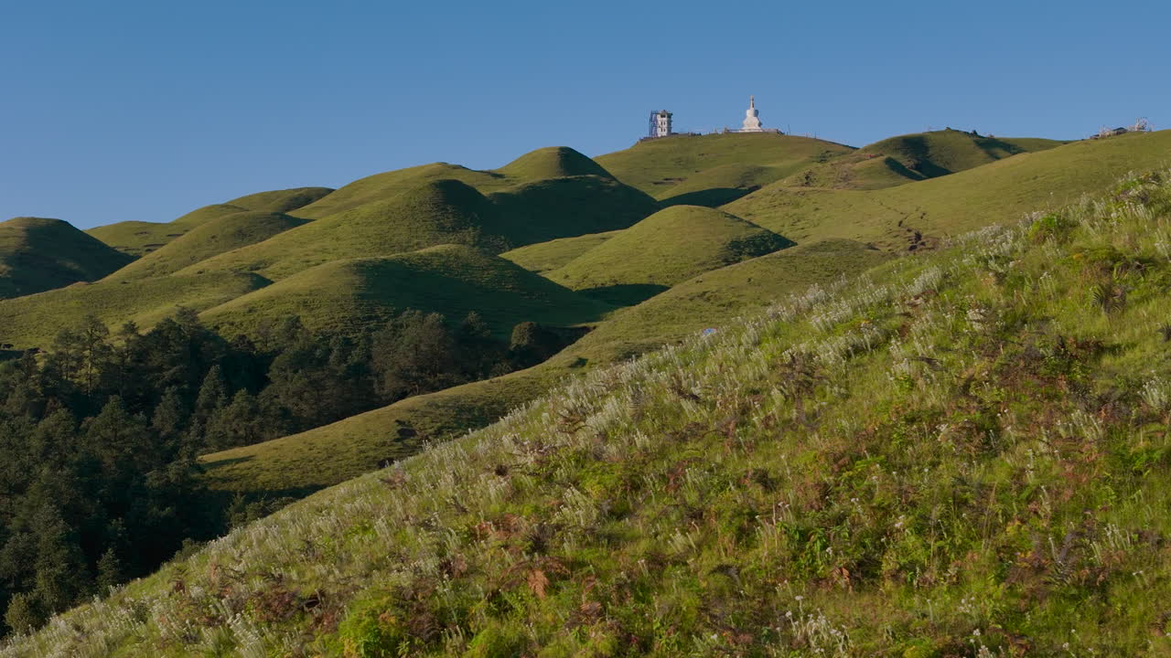 Serene Rolling Hills with Buddha Statue and Camping Tent