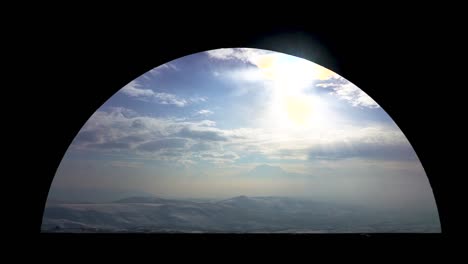 silhouette of charent's arch in armenia during sunset in the winter time with a view of the snow capped mount ararat and the frozen plains below