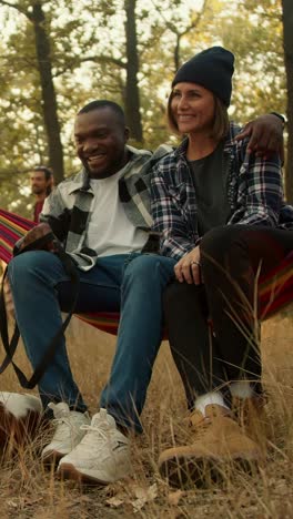 couple relaxing in hammock in forest
