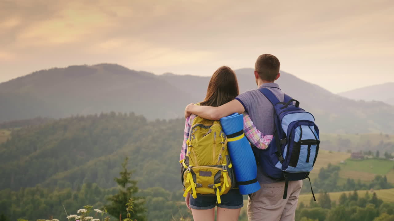 un par de jóvenes turistas con mochilas miran el avión en el cielo 1