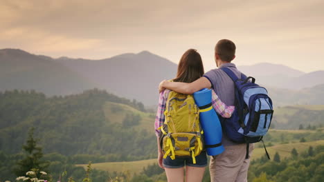 a young couple of tourists with backpacks look up at the airplane in the sky 1