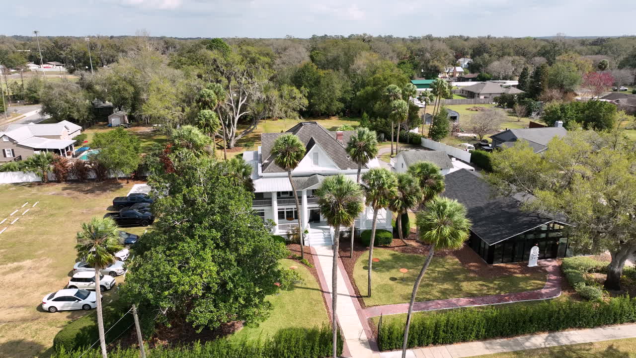 Una luminosa toma diurna con dron destaca la encantadora propiedad rural y el espacio para eventos al aire libre en Palm Mansion en Umatilla.
