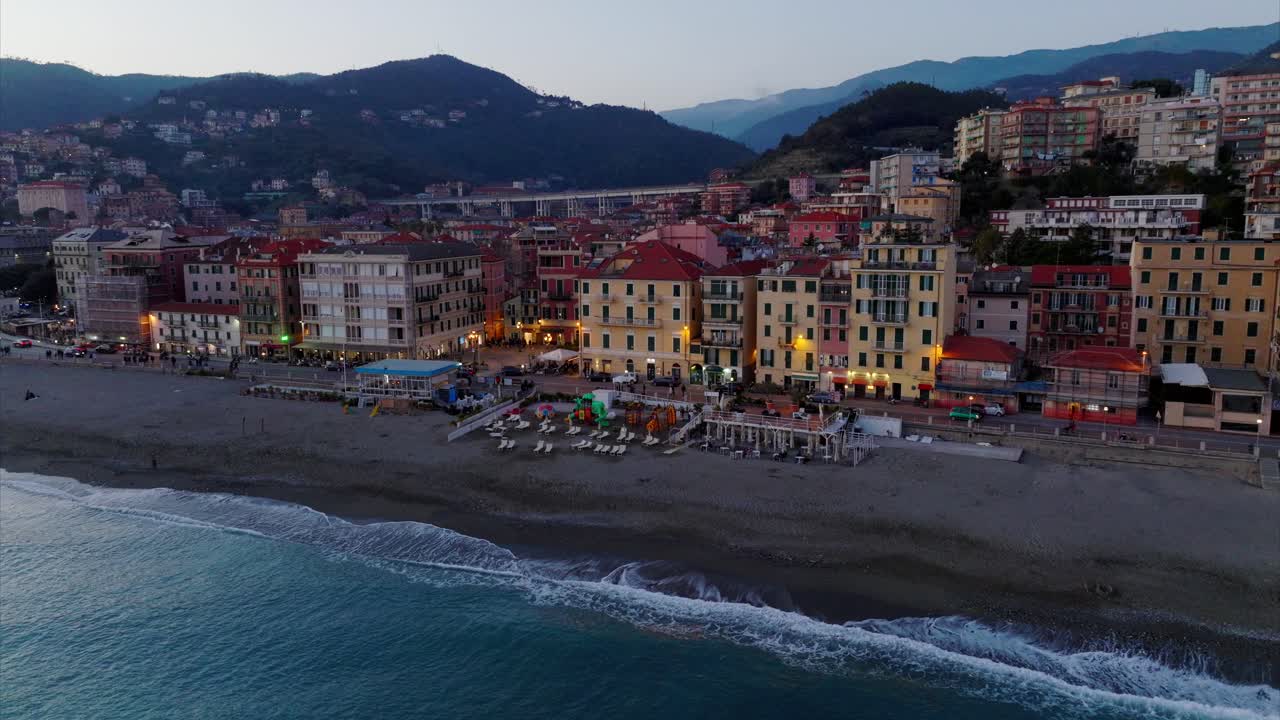 Ripresa aerea con drone di un incantevole resort balneare italiano e del vivace centro di Varazze, Liguria, al tramonto