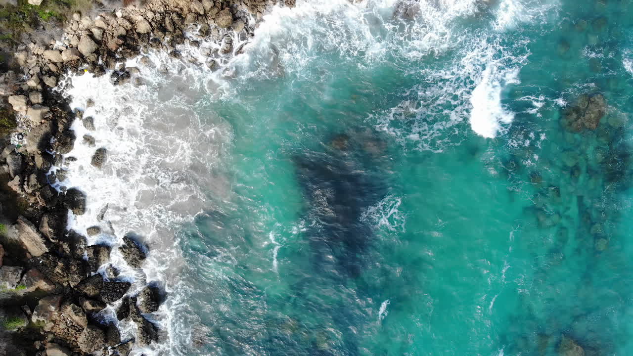 Aerial drone view of waves hitting the rocks on the shore in Limassol, Cyprus