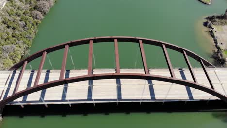 aerial austin pennybacker bridge - with bridge centered and filling frame, moving slowly towards it and then panning for a top down view while moving to center of bridge