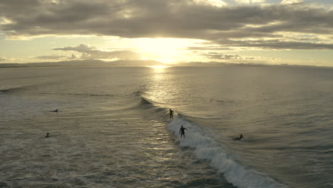 4k-Aerial-shot-of-happy-surfers-out-in-the-blue-sea-water-at-Byron-Bay,-Australia