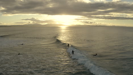 Toma-Aérea-4k-De-Surfistas-Felices-En-El-Agua-Azul-Del-Mar-En-Byron-Bay,-Australia