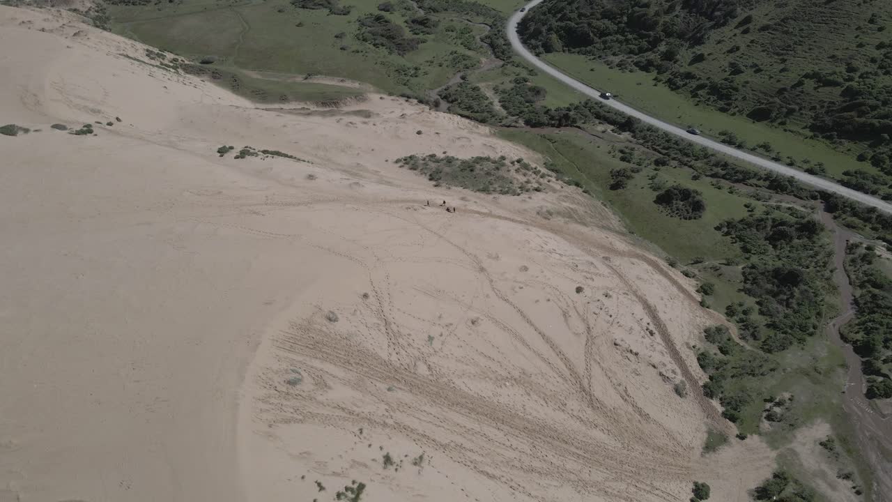 высокая частота кадров в секунду, круговой воздушный снимок людей, отдыхающих на пересечении леса и песчаных дюн в ульяни, чили