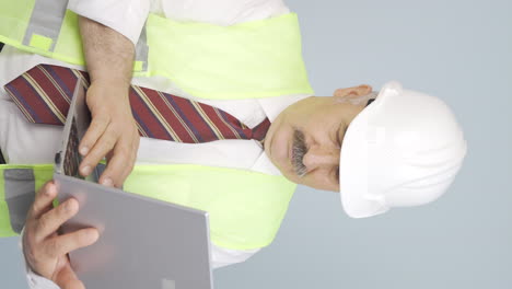 Vertical-video-of-Old-engineer-holding-laptop-laughing-at-camera.