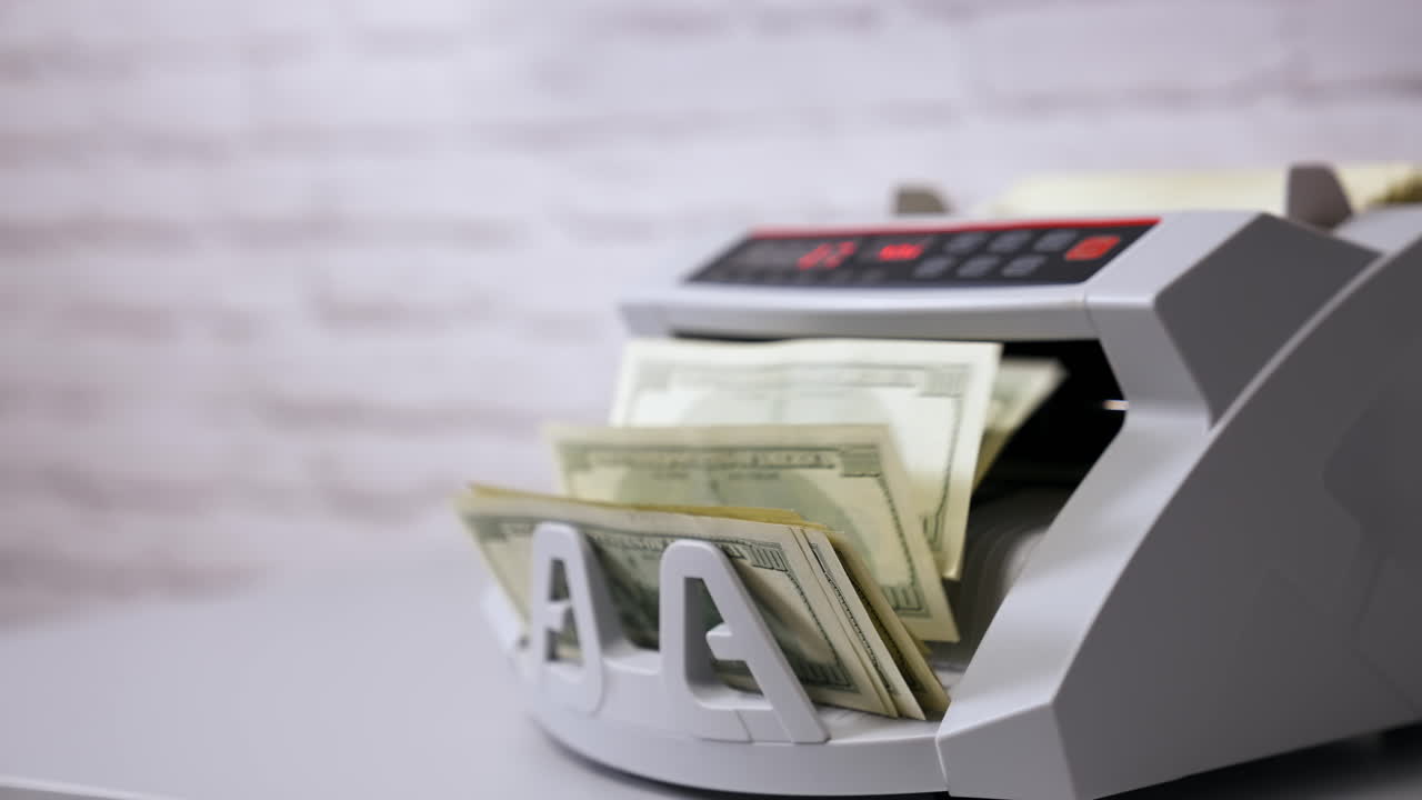 Electronic counting machine. Counter machine with US money banknotes of 100 dollars. Bank automatic equipment for counting cash money.