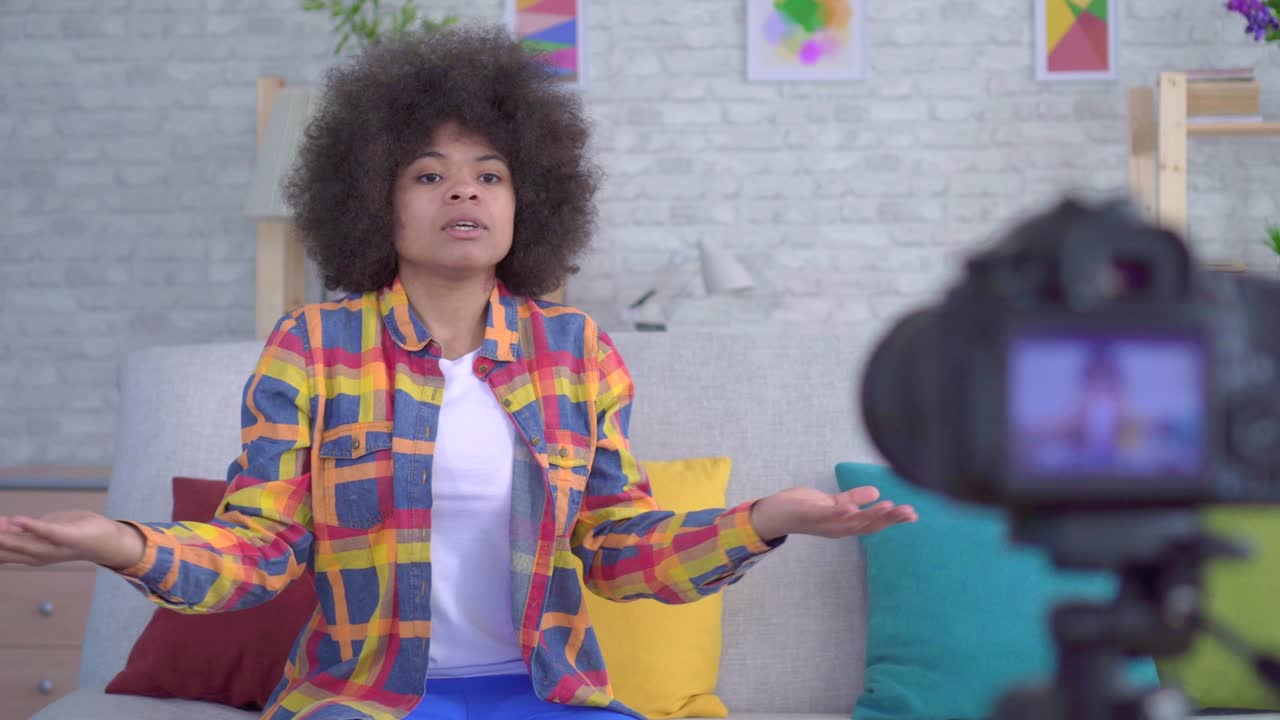 joven bloguera afroamericana con un peinado afro ante la cámara de cerca