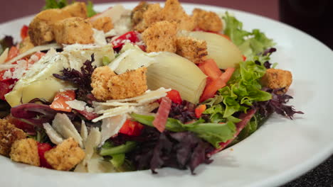 healthy nutritious italian side salad with herbed croutons artichoke hearts and shaved parmesan, slider close up 4k