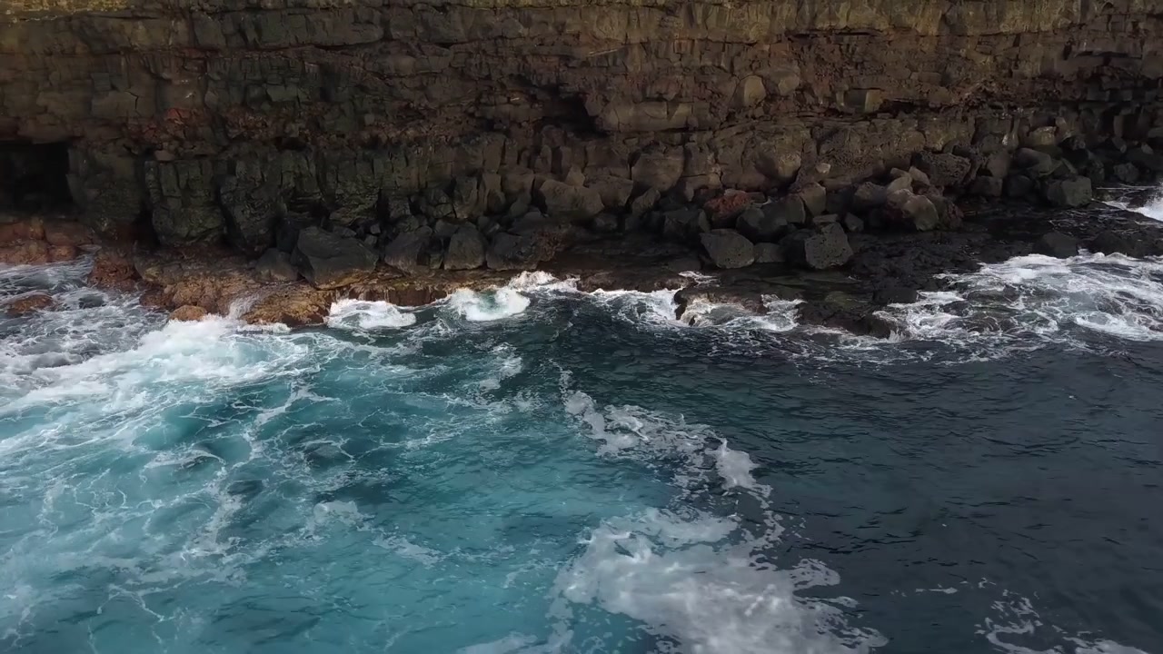 Panoramica aerea orbitale destra delle onde dell'Oceano Pacifico che si infrangono contro la costa rocciosa a scogliera della California, Nord America