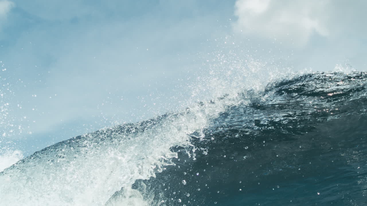 Rolling clean wave mid crest with soft glistening textures and open sky