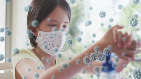 Animation-of-covid-19-cells-over-girl-wearing-face-mask-and-disinfecting-her-hands