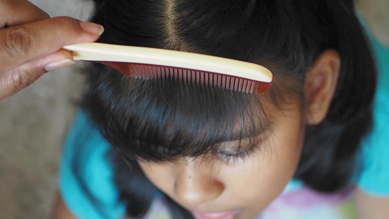 Girl getting her hair combed
