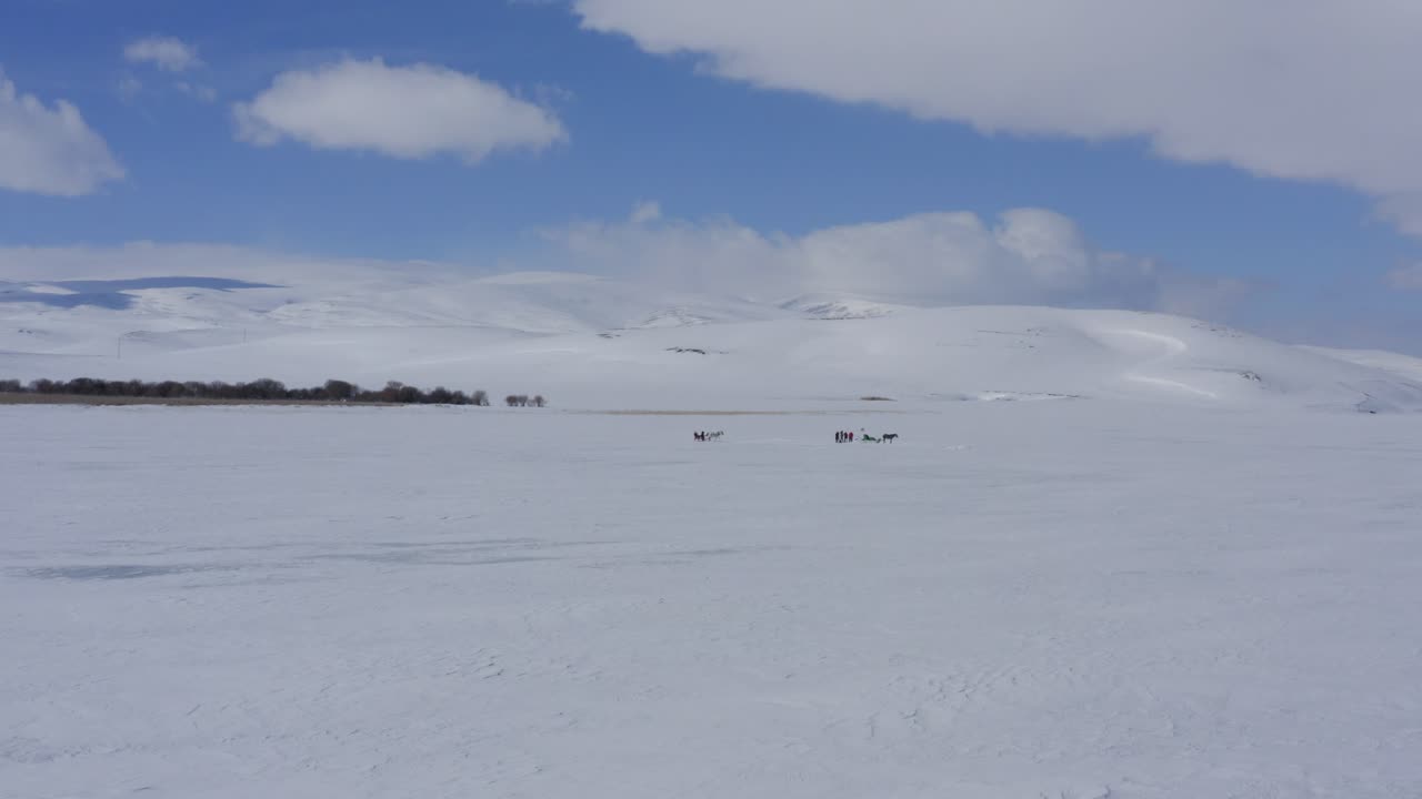 White ice landscape with white clouds in blue sky on frozen lake drone circle