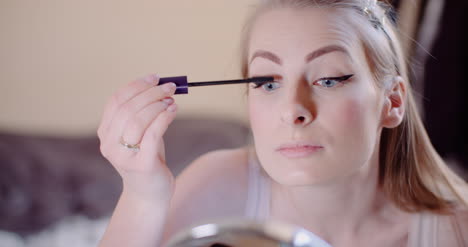 woman doing makeup painting eyelashes with mascara 11