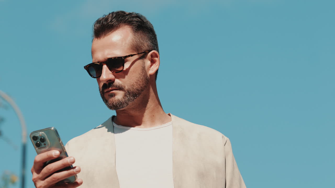 밖에서 스마트폰을 사용하는 남자