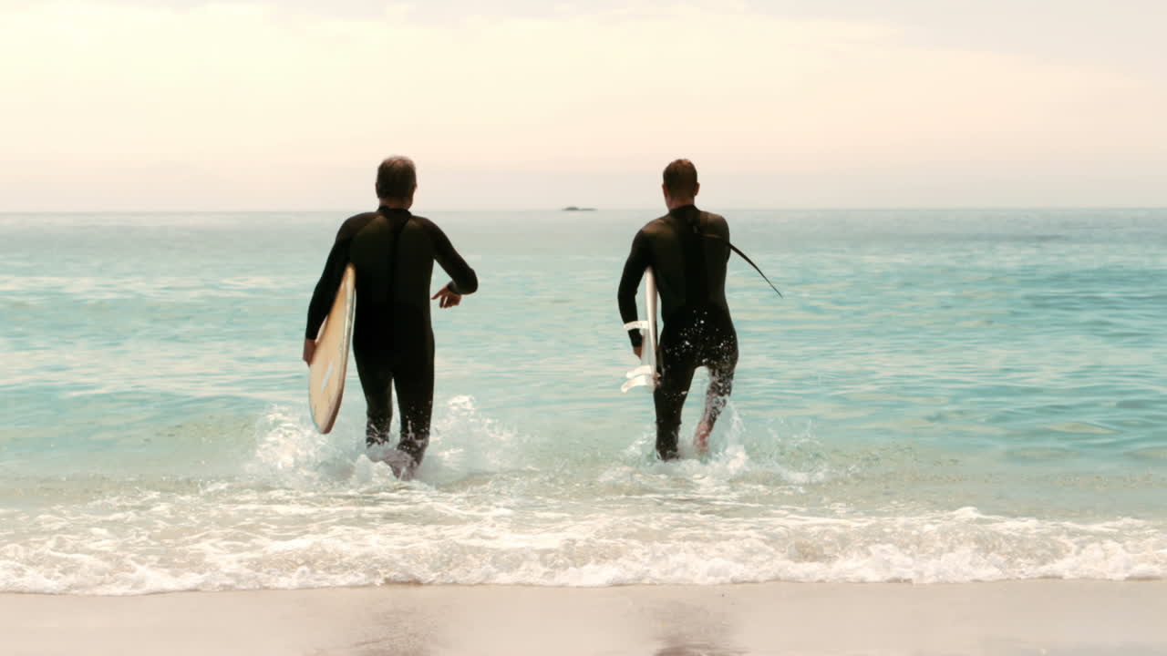 hombres con tablas de surf corriendo