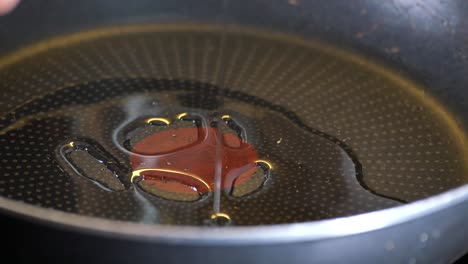 pouring oil into a frying pan