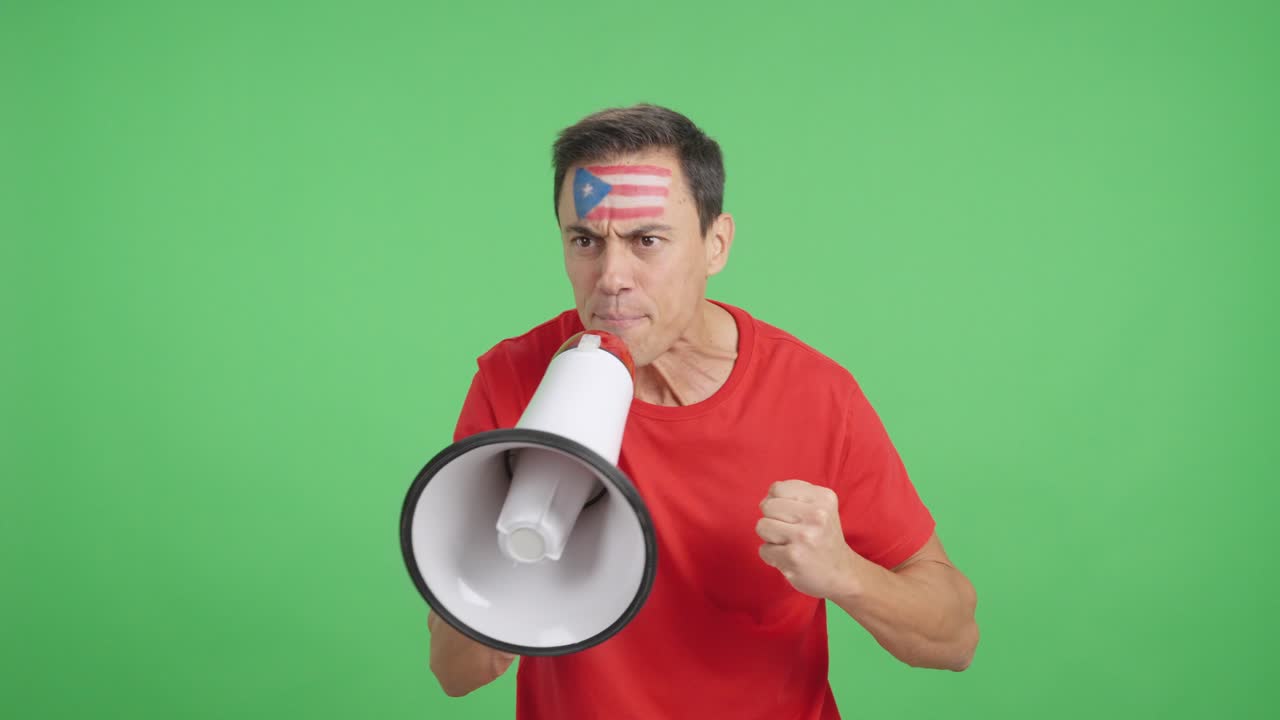 Excited man with puerto rican flag on face using a megaphone