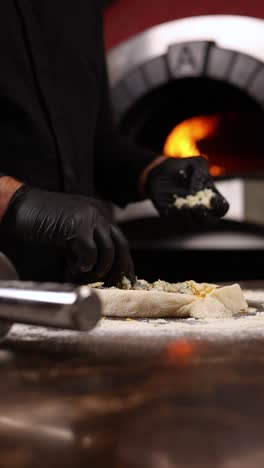 chef preparing pizza in wood-fired oven