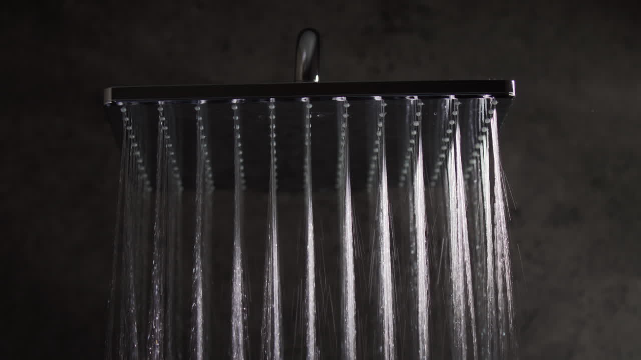 Hot water fall down from the watering can of a modern shower system