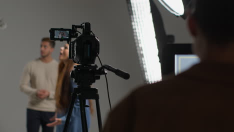 actores rodando una película o un video en un estudio vistos a través del monitor de una cámara de película con el equipo
