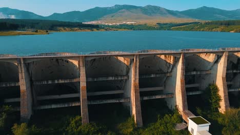 drone shot of a lake blocked by a long dam