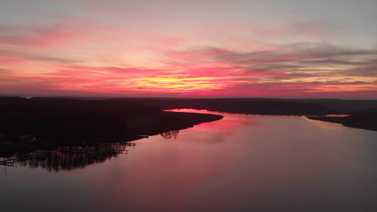 imágenes de drones giratorios de una impresionante puesta de sol con un lago y bosques a cada lado