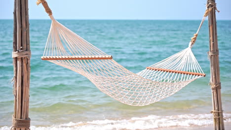 Empty-hammock-on-exotic-beach-with-sea-in-background