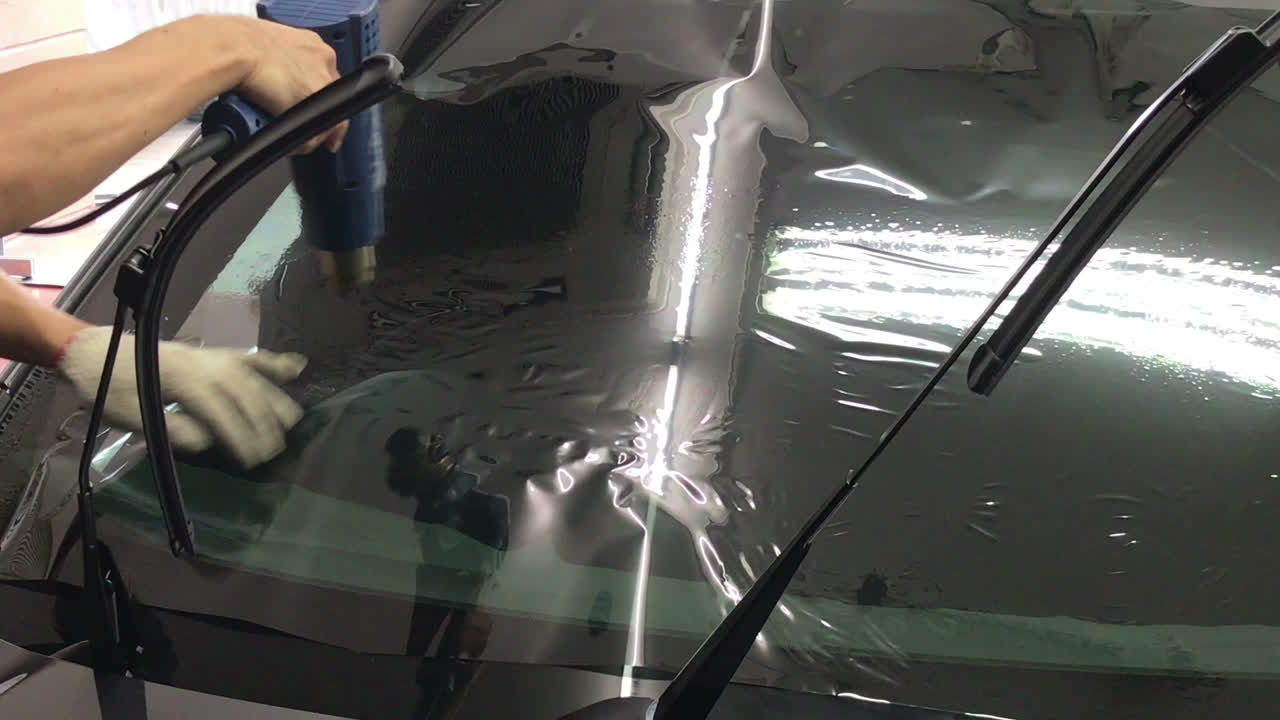 installeert een tintfilm voor het autoglas